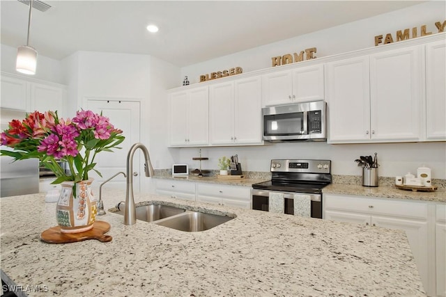 3440 Menores Way, Fort Myers, FL 33905 - kitchen with stainless steel appliances, white cabinets, pendant lighting, recessed lighting, and light stone countertops