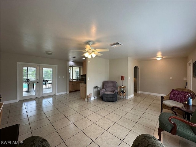 4620 Parrot Ave, Naples, FL 34104 - living room featuring arched walkways, light tile patterned floors, french doors, radiator heating unit, and ceiling fan