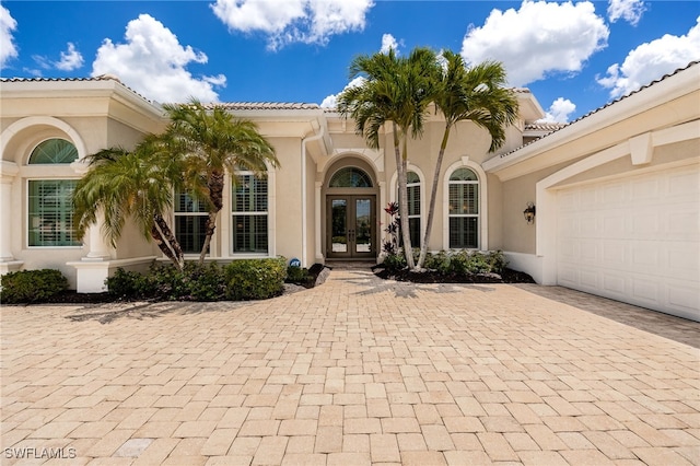 19332 La Serena Dr, Estero, FL 33967 - doorway to property featuring french doors, stucco siding, a tile roof, and an attached garage