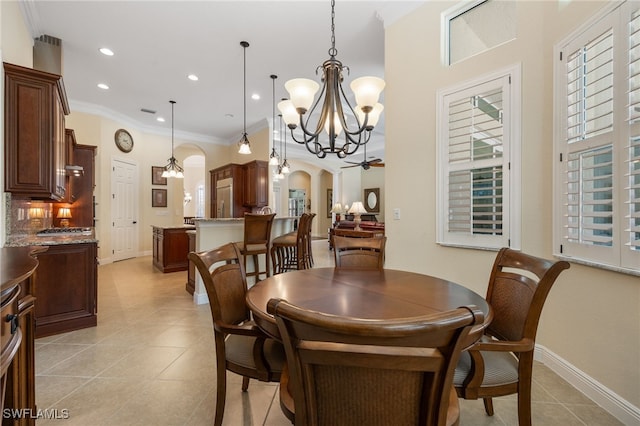 19332 La Serena Dr, Estero, FL 33967 - dining space with a chandelier, arched walkways, light tile patterned flooring, ornamental molding, and recessed lighting