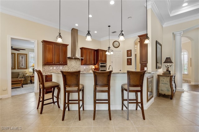 19332 La Serena Dr, Estero, FL 33967 - kitchen with wall chimney exhaust hood, arched walkways, light tile patterned floors, decorative backsplash, and a kitchen breakfast bar