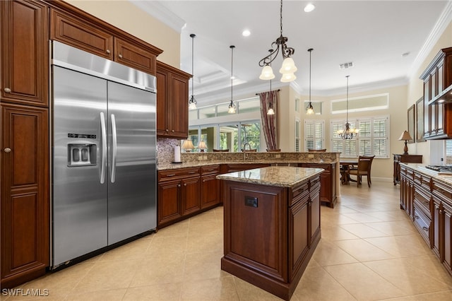 19332 La Serena Dr, Estero, FL 33967 - kitchen featuring appliances with stainless steel finishes, a chandelier, decorative backsplash, light tile patterned floors, and crown molding