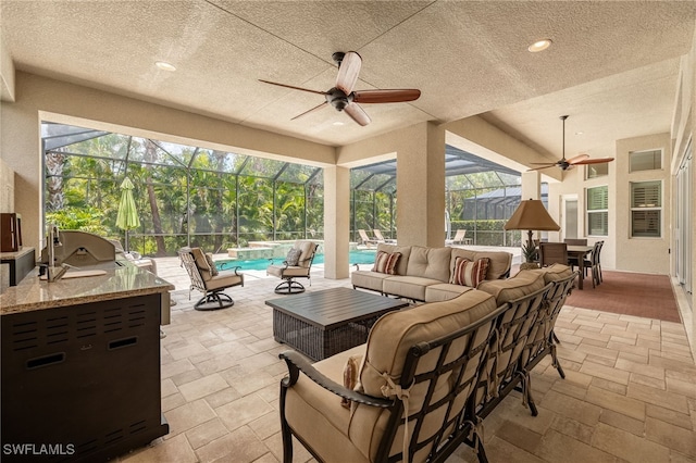 19332 La Serena Dr, Estero, FL 33967 - view of patio / terrace featuring an outdoor hangout area, a lanai, ceiling fan, exterior kitchen, and a pool with connected hot tub
