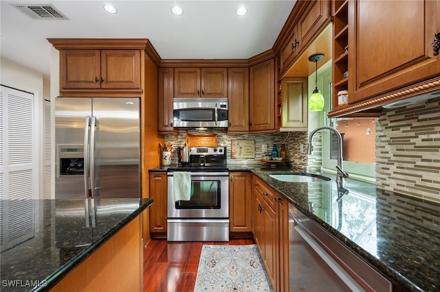 13660 Abbey Dr Unit 1, Fort Myers, FL 33919 - kitchen featuring appliances with stainless steel finishes, dark wood finished floors, brown cabinetry, decorative backsplash, and recessed lighting
