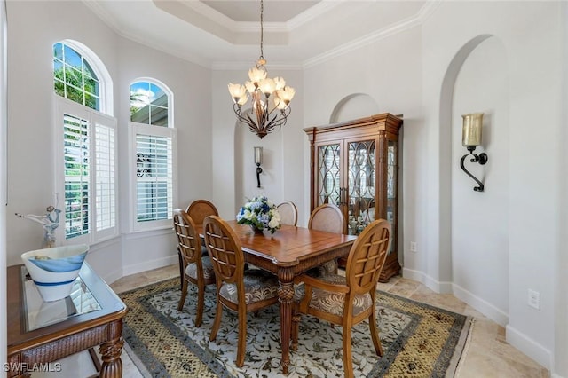 9380 Slate Ct, Naples, FL 34120 - dining area featuring plenty of natural light, a chandelier, a tray ceiling, ornamental molding, and arched walkways