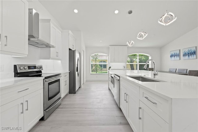 2050 Terrazzo Ln, Naples, FL 34104 - kitchen with appliances with stainless steel finishes, wall chimney range hood, white cabinets, recessed lighting, and light wood-style flooring