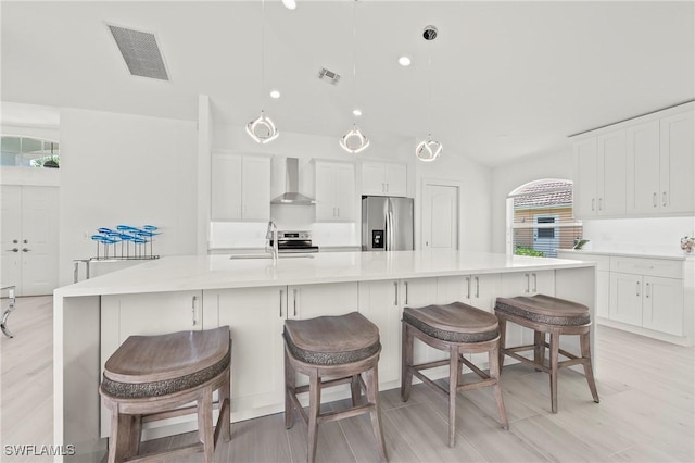 2050 Terrazzo Ln, Naples, FL 34104 - kitchen with appliances with stainless steel finishes, wall chimney range hood, white cabinetry, and vaulted ceiling