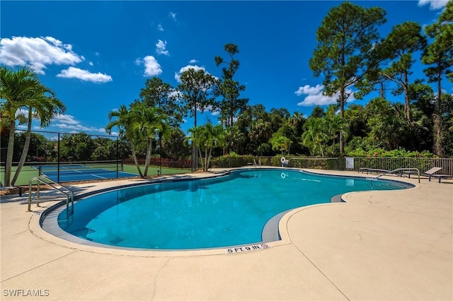 2050 Terrazzo Ln, Naples, FL 34104 - community pool with a tennis court and view of wooded area