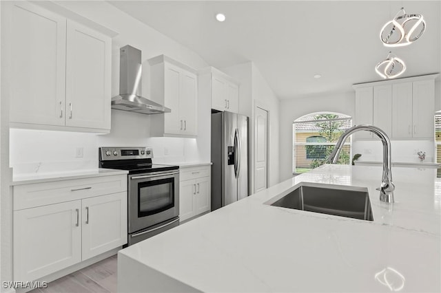 2050 Terrazzo Ln, Naples, FL 34104 - kitchen featuring stainless steel appliances, wall chimney exhaust hood, white cabinets, recessed lighting, and light wood-type flooring