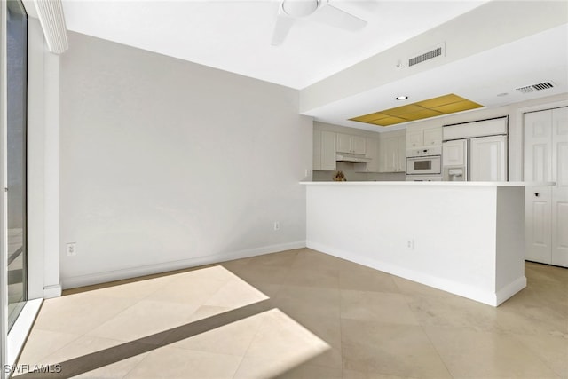 7117 Pelican Bay Blvd Unit 1801, Naples, FL 34108 - kitchen with paneled refrigerator, white oven, under cabinet range hood, a ceiling fan, and light tile patterned floors