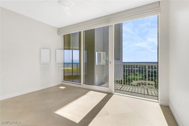 7117 Pelican Bay Blvd Unit 1801, Naples, FL 34108 - spare room featuring a ceiling fan, plenty of natural light, and tile patterned flooring