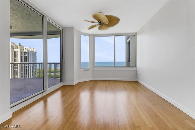 7117 Pelican Bay Blvd Unit 1801, Naples, FL 34108 - spare room with ceiling fan, wood finished floors, and a water view