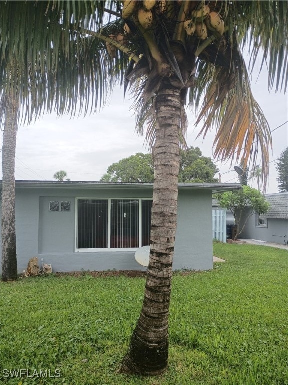 340 Easton Ct, Lehigh Acres, FL 33936 - view of property exterior with a yard and stucco siding
