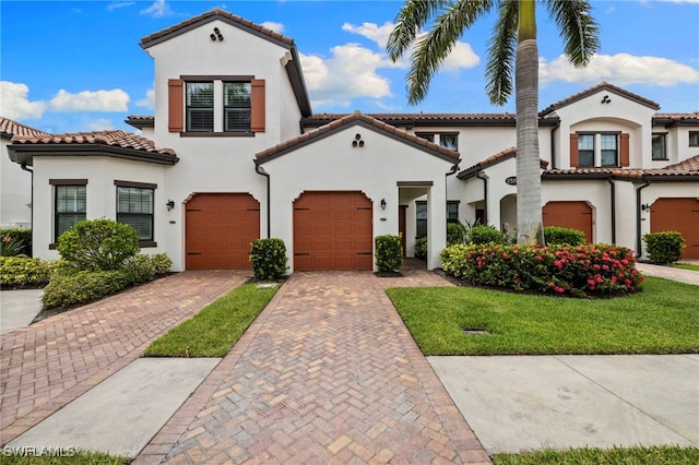 15140 Palmer Lake Cir Unit 201, Naples, FL 34109 - mediterranean / spanish-style home with stucco siding, driveway, a tiled roof, an attached garage, and a front yard