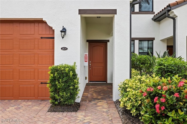 15140 Palmer Lake Cir Unit 201, Naples, FL 34109 - doorway to property with stucco siding and an attached garage
