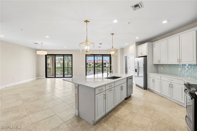 15140 Palmer Lake Cir Unit 201, Naples, FL 34109 - kitchen featuring stainless steel appliances, backsplash, recessed lighting, white cabinetry, and a kitchen island with sink