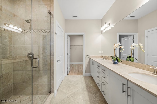 15140 Palmer Lake Cir Unit 201, Naples, FL 34109 - full bath with double vanity, a stall shower, a spacious closet, and tile patterned floors