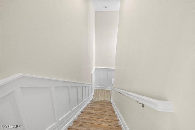 15140 Palmer Lake Cir Unit 201, Naples, FL 34109 - stairway featuring wood finished floors, wainscoting, and a decorative wall
