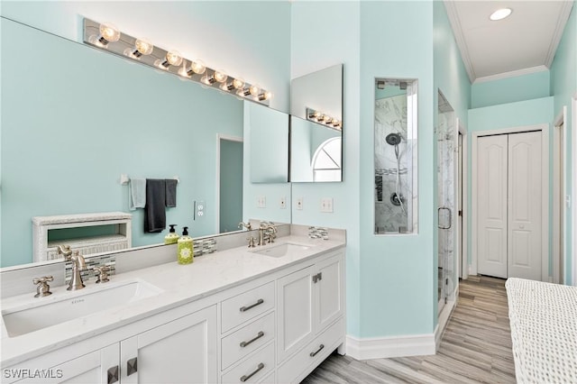 8014 Kilkenny Ct Unit G47, Naples, FL 34112 - full bathroom with crown molding, double vanity, a stall shower, wood finished floors, and recessed lighting