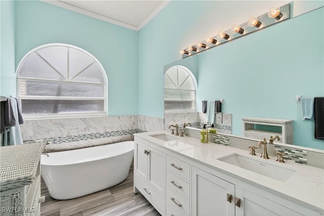 8014 Kilkenny Ct Unit G47, Naples, FL 34112 - full bath with a freestanding tub, double vanity, tile walls, crown molding, and wainscoting