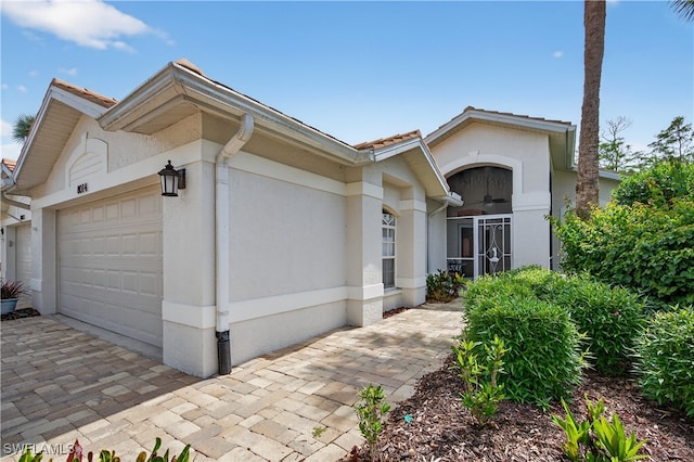 8014 Kilkenny Ct Unit G47, Naples, FL 34112 - view of front of home featuring a garage, stucco siding, driveway, and ceiling fan