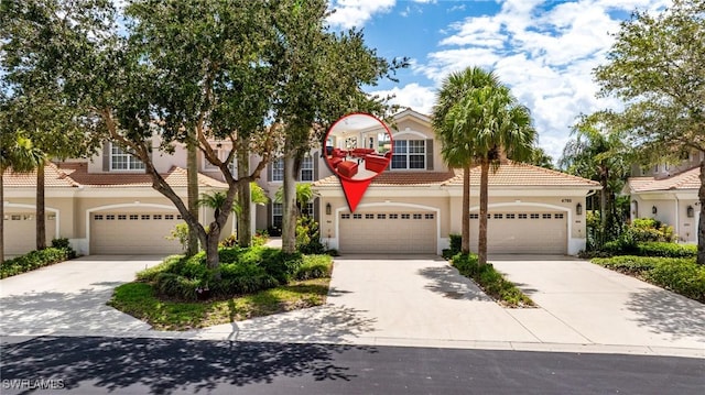 4780 Shinnecock Hills Ct Unit 102, Naples, FL 34112 - view of front of house featuring stucco siding, a tile roof, concrete driveway, and a garage