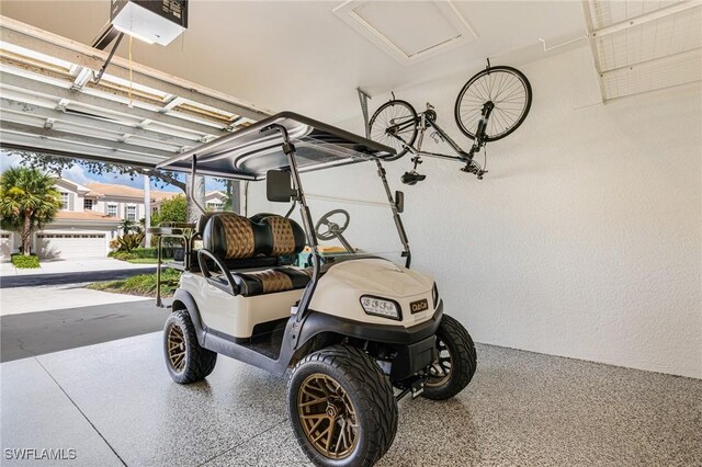 4780 Shinnecock Hills Ct Unit 102, Naples, FL 34112 - garage with a garage door opener and a textured wall