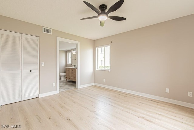 7718 Jewel Ln Unit 101, Naples, FL 34109 - unfurnished bedroom with light wood-style flooring, a closet, ensuite bath, and ceiling fan