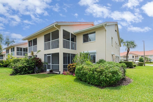 7718 Jewel Ln Unit 101, Naples, FL 34109 - rear view of house featuring stucco siding, a yard, and a sunroom