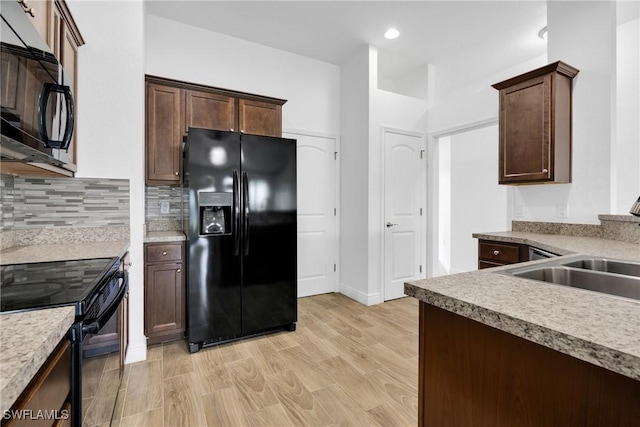 2920 6th St SW, Lehigh Acres, FL 33976 - kitchen featuring black appliances, light wood-style flooring, tasteful backsplash, dark brown cabinets, and recessed lighting