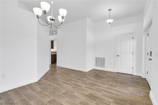 2920 6th St SW, Lehigh Acres, FL 33976 - unfurnished room with a chandelier and light wood-style flooring