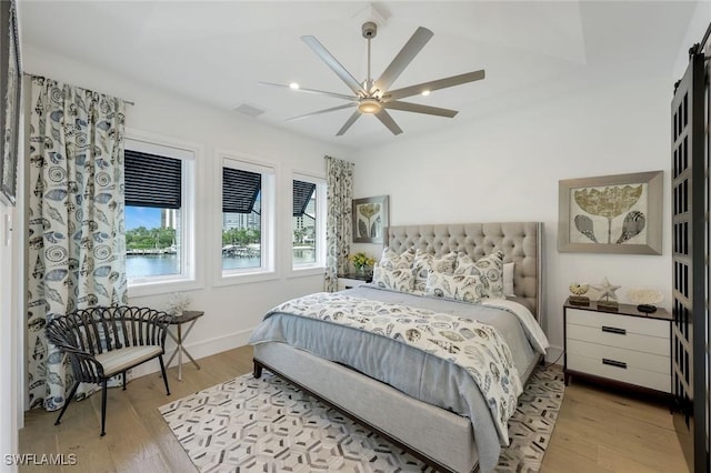 309 Neapolitan Way, Naples, FL 34103 - bedroom with multiple windows, light wood finished floors, and a ceiling fan