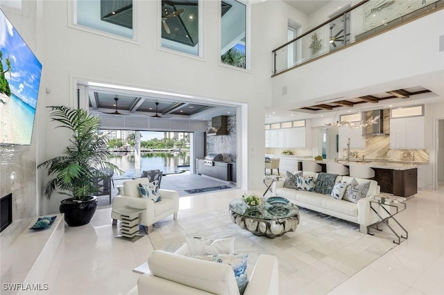309 Neapolitan Way, Naples, FL 34103 - living area featuring coffered ceiling, a high ceiling, beam ceiling, a water view, and light tile patterned floors