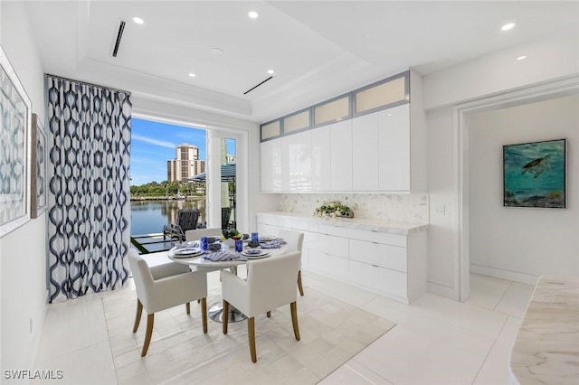 309 Neapolitan Way, Naples, FL 34103 - dining space featuring a tray ceiling, recessed lighting, a water view, and light tile patterned floors