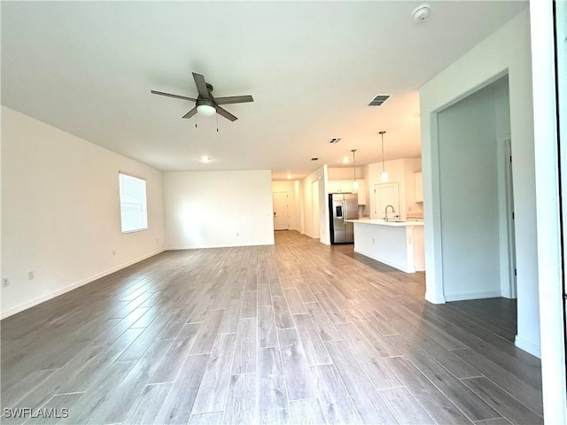 2667 Scarlet Way, Naples, FL 34120 - unfurnished living room with wood finished floors and ceiling fan