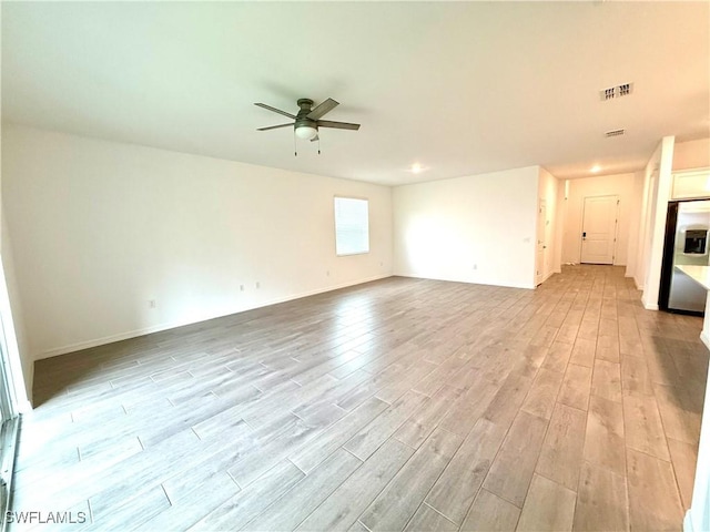 2667 Scarlet Way, Naples, FL 34120 - unfurnished living room featuring a ceiling fan and light wood-style flooring
