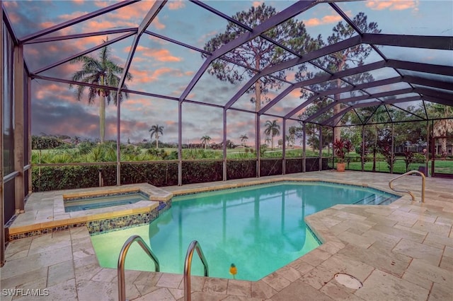 4582 Fairloop Run, Lehigh Acres, FL 33973 - pool at dusk featuring a pool with connected hot tub and a patio