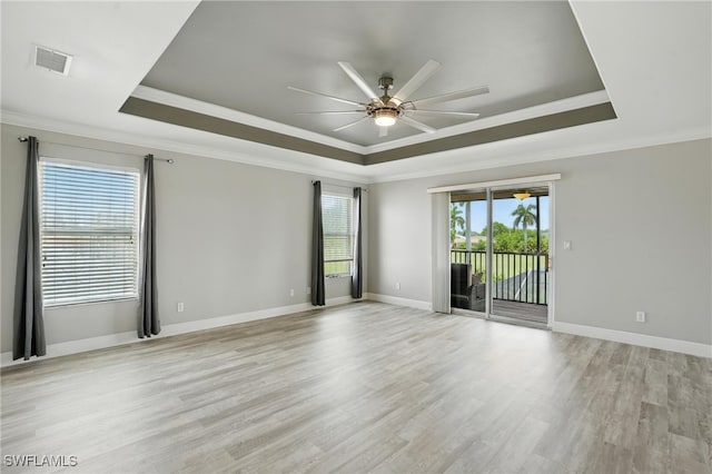 4582 Fairloop Run, Lehigh Acres, FL 33973 - spare room featuring a tray ceiling, ceiling fan, crown molding, and light wood-style floors