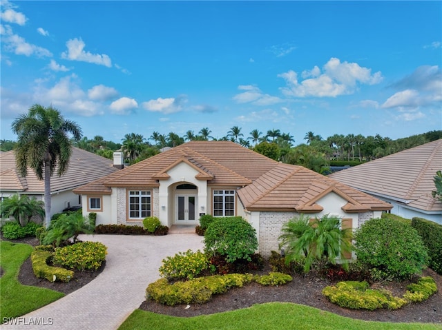 3262 Sedge Pl, Naples, FL 34105 - ranch-style house with french doors, a tile roof, stucco siding, and decorative driveway