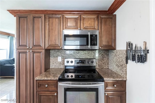 401 NE 14th Pl, Cape Coral, FL 33909 - kitchen with appliances with stainless steel finishes, light stone counters, and decorative backsplash