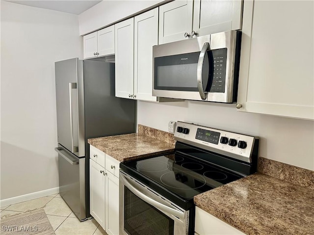 13118 Feather Sound Dr Unit 208, Fort Myers, FL 33919 - kitchen with stainless steel appliances, white cabinets, dark countertops, and light tile patterned floors