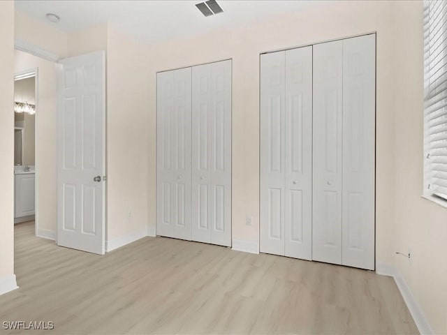 6491 Marbella Dr, Naples, FL 34105 - unfurnished bedroom with light wood-type flooring and two closets