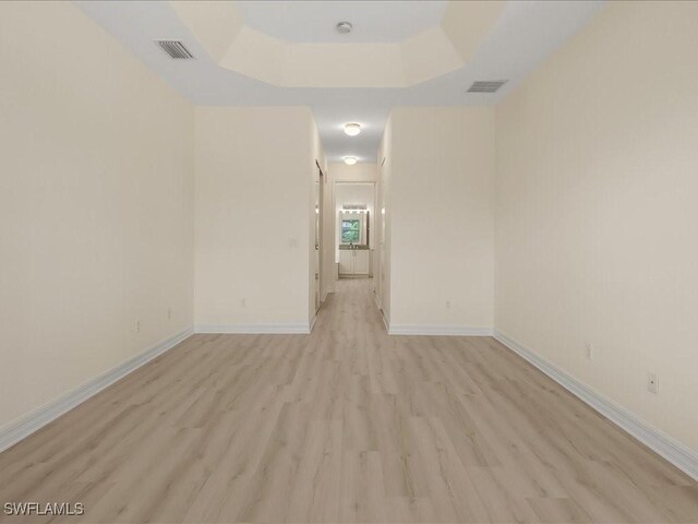 6491 Marbella Dr, Naples, FL 34105 - unfurnished room featuring light wood finished floors and a raised ceiling