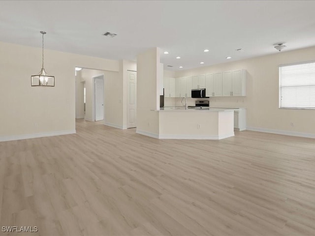 6491 Marbella Dr, Naples, FL 34105 - unfurnished living room featuring light wood-style flooring, a chandelier, and recessed lighting