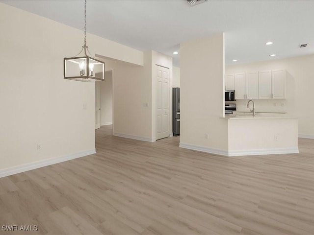 6491 Marbella Dr, Naples, FL 34105 - unfurnished living room featuring a chandelier, light wood-style flooring, and recessed lighting