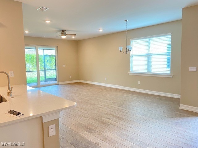 1023 Enbrook Loop, Naples, FL 34114 - unfurnished living room with ceiling fan, light wood-style flooring, recessed lighting, and a chandelier