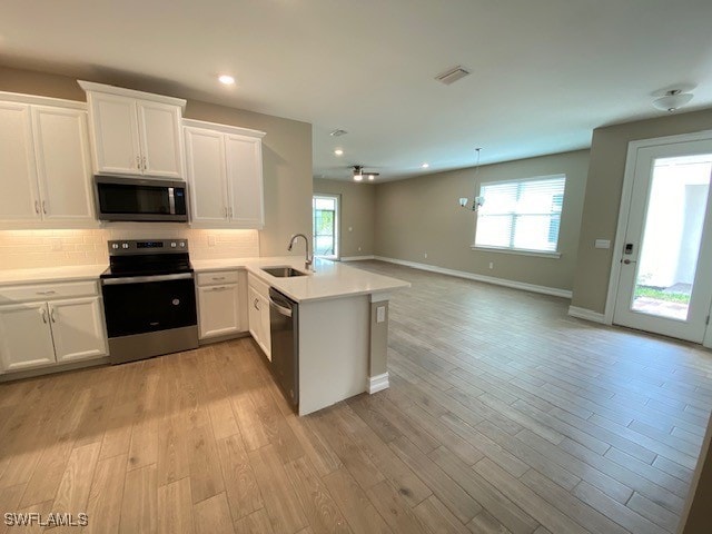 1023 Enbrook Loop, Naples, FL 34114 - kitchen featuring appliances with stainless steel finishes, a peninsula, tasteful backsplash, white cabinetry, and recessed lighting