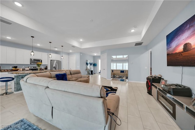 1421 SW 13th Ter, Cape Coral, FL 33991 - living room with a tray ceiling, recessed lighting, and light tile patterned floors