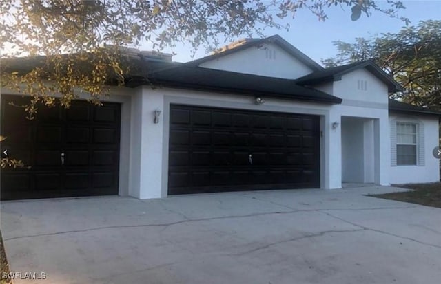 4839 18th St NE Unit 1, Naples, FL 34120 - view of front facade featuring a garage, concrete driveway, and stucco siding