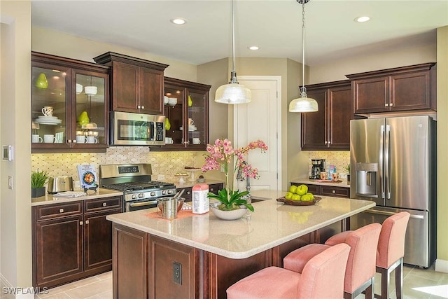 4088 Pegasus Way, Naples, FL 34120 - kitchen with stainless steel appliances, a kitchen bar, tasteful backsplash, a center island, and recessed lighting